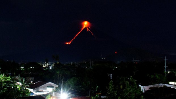 More than 9000 people have evacuated the area around the Philippines' most active volcano as lava flowed down its crater on Monday in a gentle eruption that scientists warned could turn explosive. 