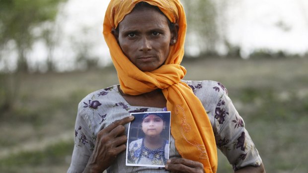 Rohiakar, a Rohingya Muslim woman, shows a picture of her daughter Saywar Nuyar, 22, who is being held by a human trafficker, at a refugee camp outside Sittwe, Myanmar. 