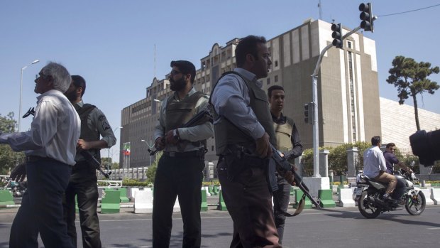 Police officers stand outside Iran's parliament building following an attack by several gunmen on June 7.