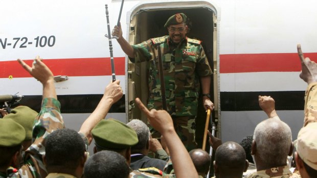 Omar al-Bashir is greeted by military soldiers as he arrives at an airport in Heglig in 2012.