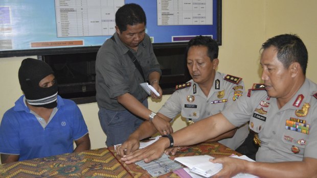 From left, seated: Captain Yohanis Humiang with head of the people-smuggling division of Nusa Tenggara Timur, Ibrahim, and Rote police chief Hidayat in June.