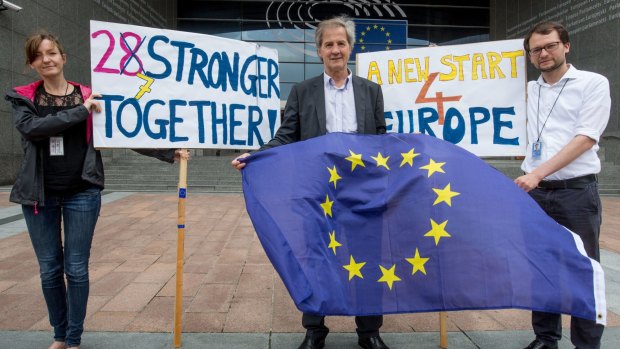 Jo Leinen, centre, a German member of the European Parliament, holds an EU flag outside the parliament in Brussels on Friday.