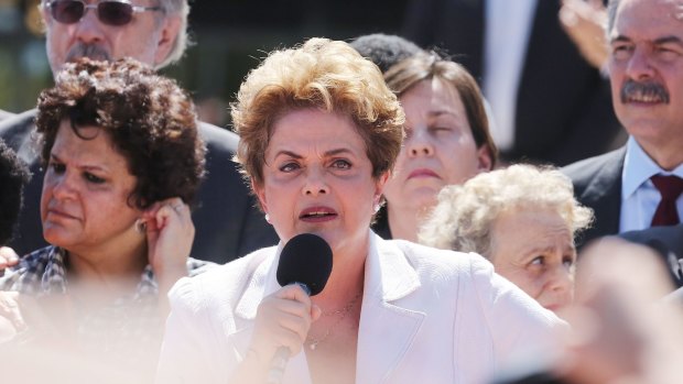 Dilma Rousseff (centre) speaks to supporters after being suspended.
