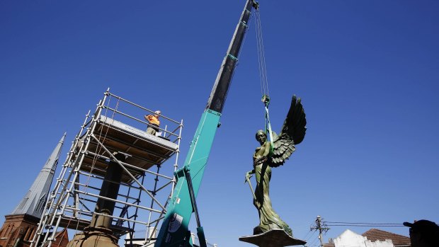 The Winged Victory statue is hoisted by a crane on to her final resting place in front of the Marrickville Town Hall. 