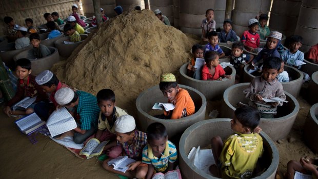 Rohingya refugee children attend recitation classes of the Koran in a newly opened madrasa, or religious school, amid material stocked for constructing latrines in Balukhali refugee camp, Bangladesh.