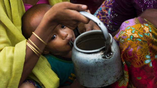 A child drinks water as Rohingya Muslims who have fled persecution in Myanmar wait along the Bangladesh border for permission to move further towards refugee camps on Thursday.