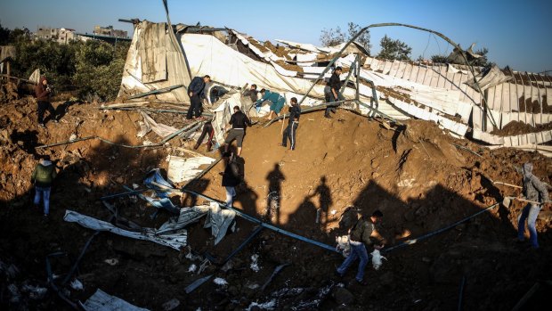 Palestinians inspect the wreckage of a chicken farm in hit by an Israeli air strike on Shujaya, Gaza.