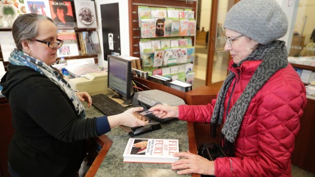 Rebecca Burgess, left, sells a copy of "Fire and Fury: Inside the Trump White House"to Susan Vander Veer, in Illinois. 