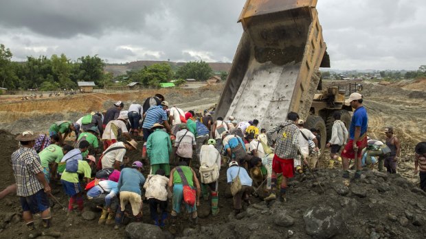 Jade miners search for raw jade stones in an earth dump from a company's truck in Hpakant area, Kachin State, Northern Myanmar. 