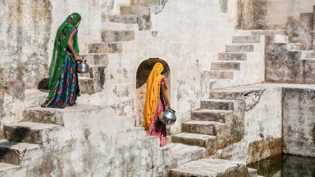 Women in saris carrying water at step well, Jaipur.