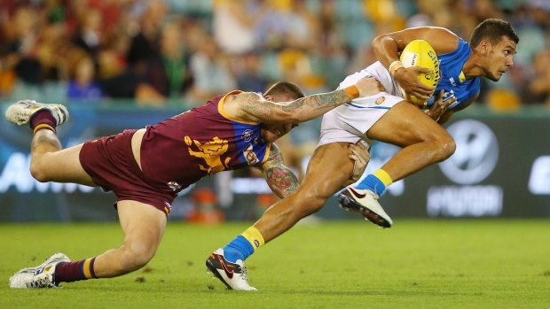 Callum Ah Chee of the Suns is tackled by Claye Beams of the Lions.