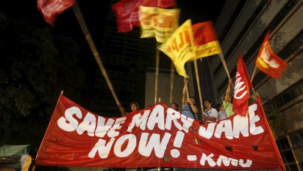 Activists wave flags after it was announced that Veloso's execution had been stayed. 