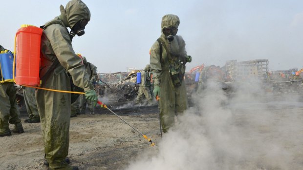 Soldiers from a People's Liberation Army chemical-defence unit work to neutralise sodium cyanide residue at the Tianjin blast site.