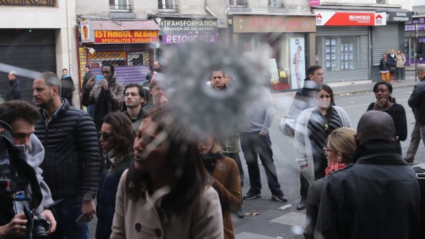 A crowd gathers as the police cordon is lifted at La Belle Equipe cafe.