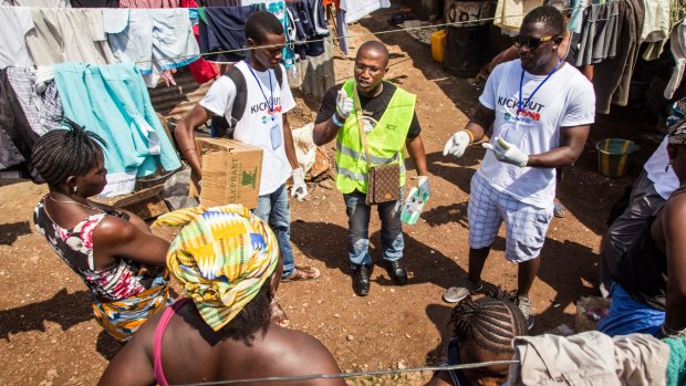 A volunteer health worker speaks with Freetown residents about identifying and preventing the spread of Ebola on September 20.