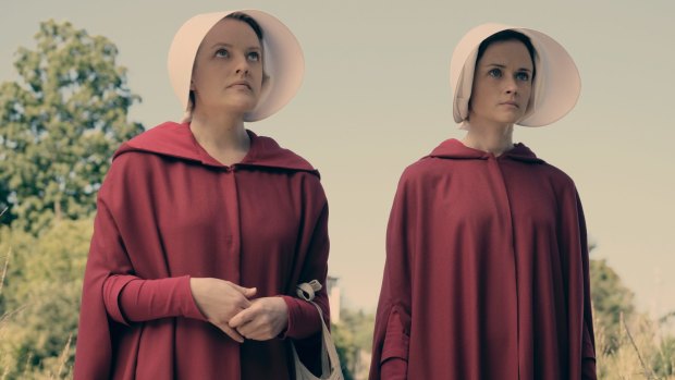Women stripped of their rights and forced to bear children for the elite:  Elisabeth Moss (left) as Offred and Alexis Bledel as Ofglen in <i>The Handmaid's Tale</i>.
