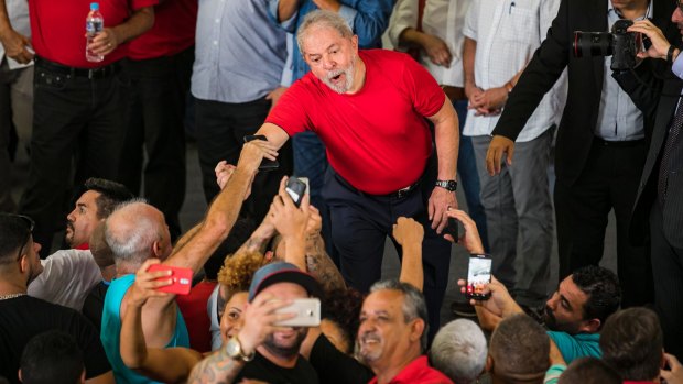 Most popular: former president Lula da Silva greets members of the meal workers' union on Wednesday. 