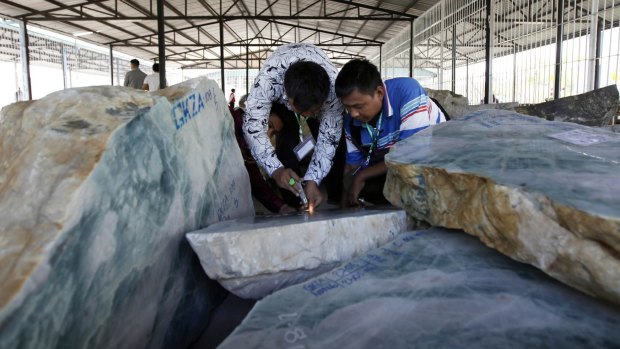 Merchants inspect jade displayed at the Gems Emporium in Naypyitaw earlier this month. 