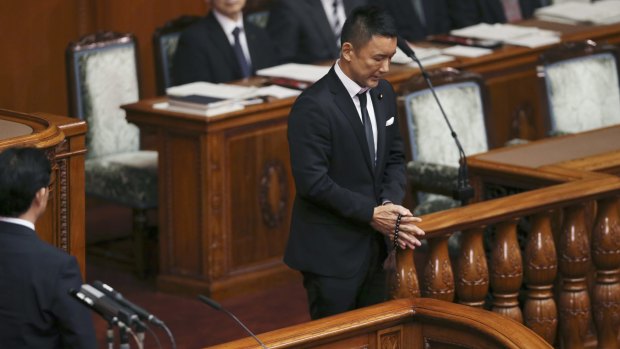 Wearing a black tie, lawmaker Taro Yamamoto of Japan's opposition party "Yamamoto Taro and his friends" prays with Buddhist prayer beads during voting on a censure motion filed by the major opposition Democratic Party against Prime Minister Shinzo Abe at the upper house plenary diet session in Tokyo on Friday.