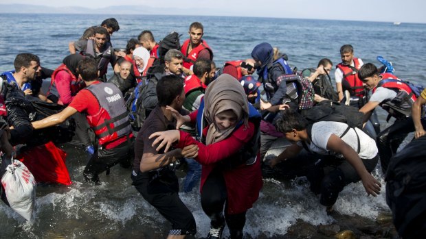 Refugees arrive on a dinghy after crossing from Turkey to Lesbos Island, Greece.