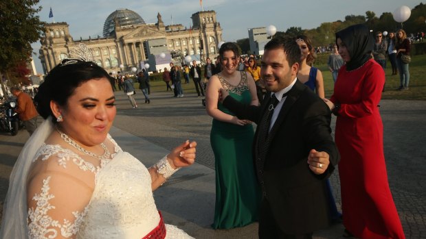 A Turkish wedding party makes a stop to play music and dance briefly near the Reichstag on the 25th anniversary of German reunification on October 3  in Berlin.