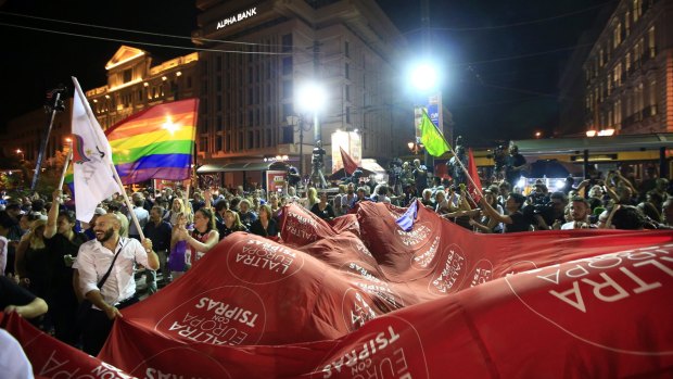 Syriza party supporters with a giant flag that reads in Italian: "The other Europe with Tsipras".