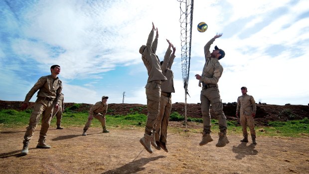 New conscripts to Rojava's army play volleyball during a break from training at an abandoned Syrian military base near Ramalan.  