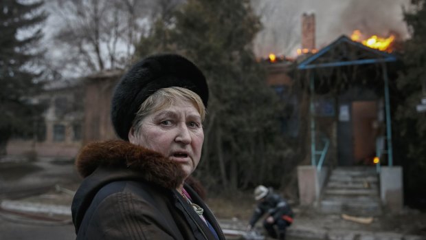 A woman in front of a burning building after shelling in Artemivsk, eastern Ukraine on Saturday, hours before the scheduled ceasefire. 