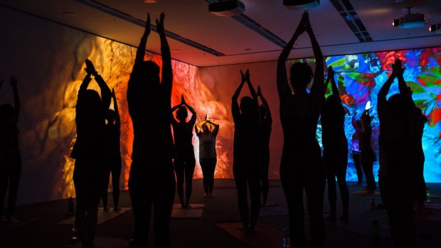 People doing yoga in the Pipilotti Rist exhibition space at the National Gallery of Australia.  