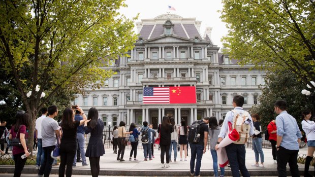 The Chinese flag is displayed next to the American flag on the side of the Old Executive Office Building in the White House complex in Washington, the day before a state visit by Chinese President Xi Jinping.