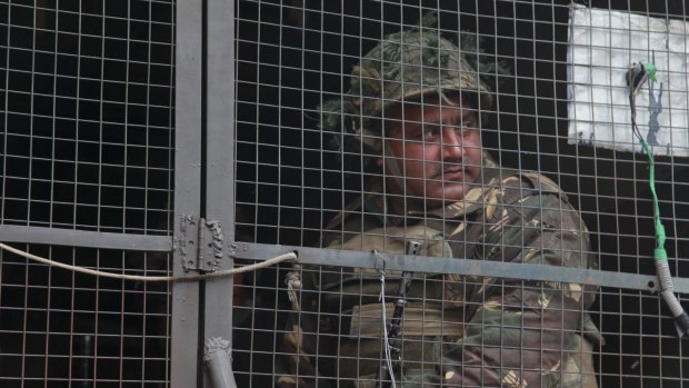 An Indian army soldier looks from inside an army vehicle at the Indian air force base in Pathankot, India, on Monday. 