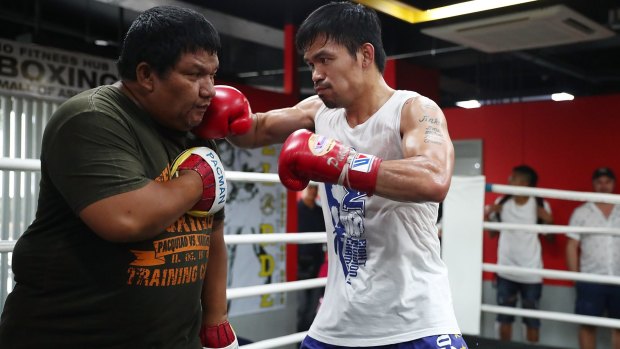 Manny Pacquiao hits the pads with Buboy Fernandez. By the end, the trainer is drenched in as much sweat as the fighter.