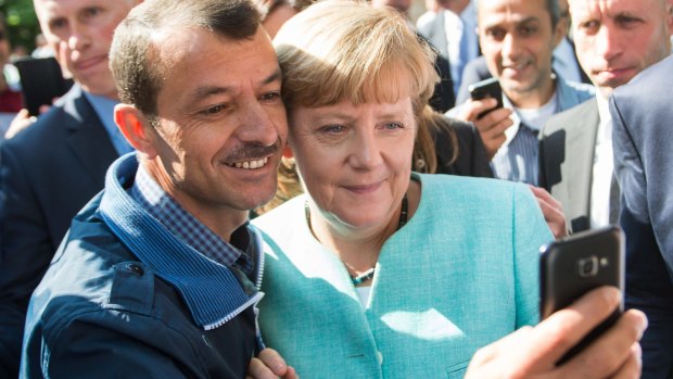 German Chancellor Angela Merkel has pictures taken with refugees at a reception centre for asylum seekers in Berlin last year.