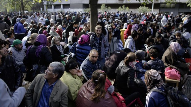 Hundreds of migrants and refugees wait outside Berlin's State Office of Health and Welfare, Lageso.