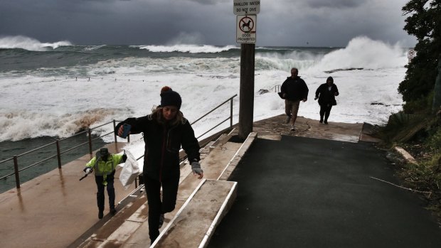 Sightseers scramble to safety as big waves lash Dee Why beach.