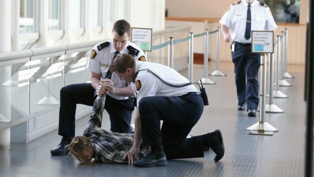 Security guards drag a man out of the House of Representatives.