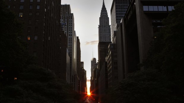 The sun shines down 42nd Street below the landmark "Chrysler Building" (R) in New York City at sunset during the biannual occurrence named "Manhattanhenge" in New York.