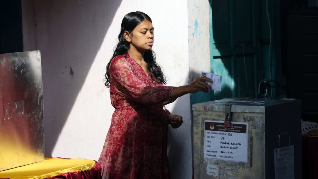 An Indonesian woman casts her ballot.