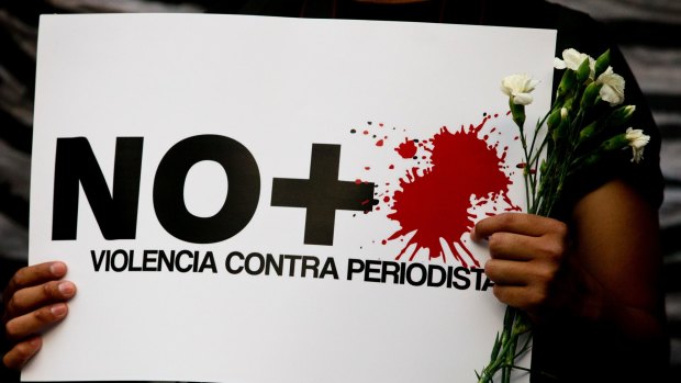 A protester holds a sign reading "No more violence against journalists". Since 2000, at least 125 journalists have been killed in Mexico.