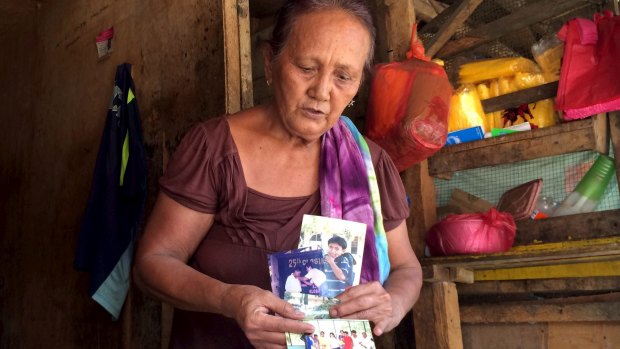 Clarita Alia, 62, in Davao, holds up photographs of four teenage sons killed by vigilantes - she blames Philippine president elect, Rodrigo Duterte.