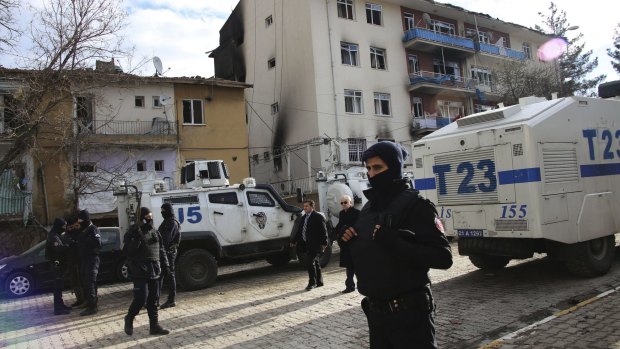 Turkish police officers secure the area around a destroyed police station compound in Cinar.