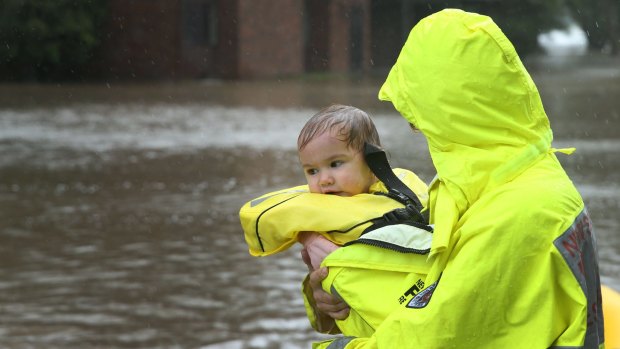 Rochelle Wright and her one-year old daughter Amelia taken to safety at Raymond Terrace on Wednesday.