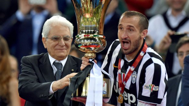 Juventus captain Giorgio Chiellini, right, receives  the trophy.