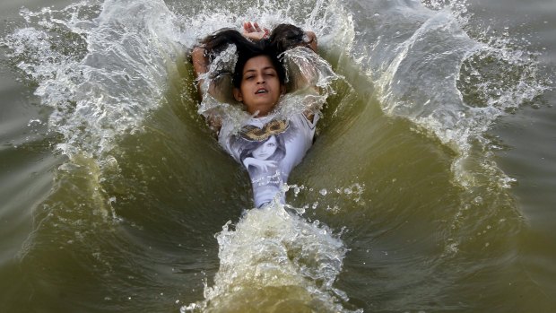 A girl cools off herself in the waters of the river Ganges in Allahabad, India.