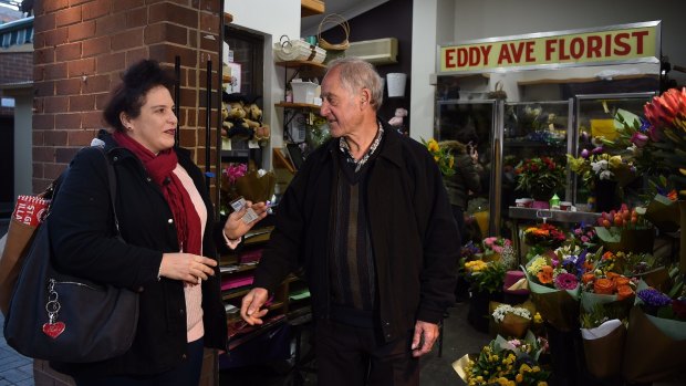 A woman talks to florist Emmanuel Theoharis as he stands in his Eddy Avenue shop on Thursday morning.
