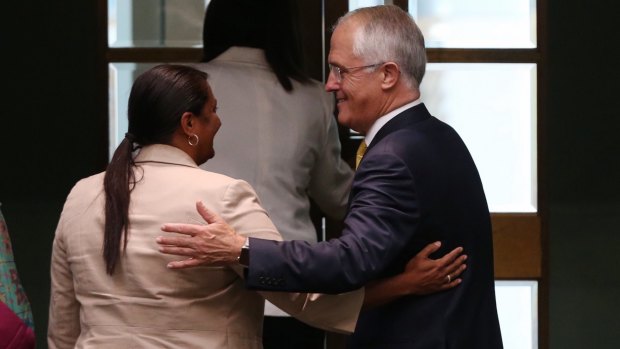 Mr Turnbull embraces Labor Senator Nova Peris after he delivered the report.