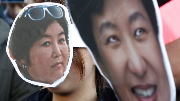 South Korean protesters wear masks of President Park Geun-hye, right, and Choi Soon-sil, while calling for Park to step down on Wednesday.