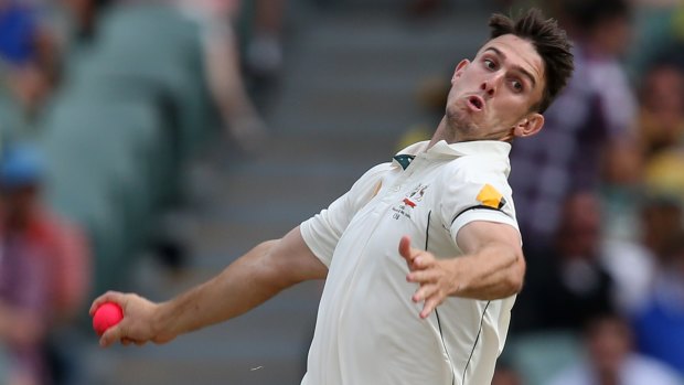 Pinkish hue: Mitchell Marsh bowls sends one down during the first day-night Test.
