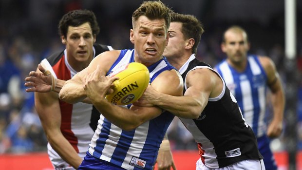 MELBOURNE, AUSTRALIA - JUNE 16: Shaun Higgins of the Kangaroos handballs whilst being tackled by Jack Sinclair of the Saints during the round 13 AFL match between the North Melbourne Kangaroos and the St Kilda Saints at Etihad Stadium on June 16, 2017 in Melbourne, Australia. (Photo by Quinn Rooney/Getty Images)