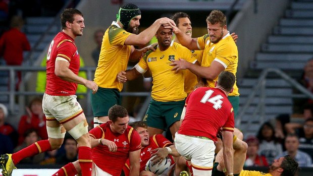 Tough times: Australian players celebrate after winning a penalty to relieve Welsh pressure on their tryline.